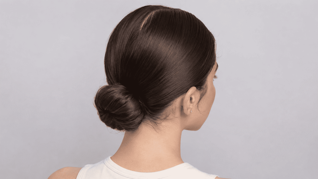 Sleek center-parted low bun hairstyle for hot and humid August days
