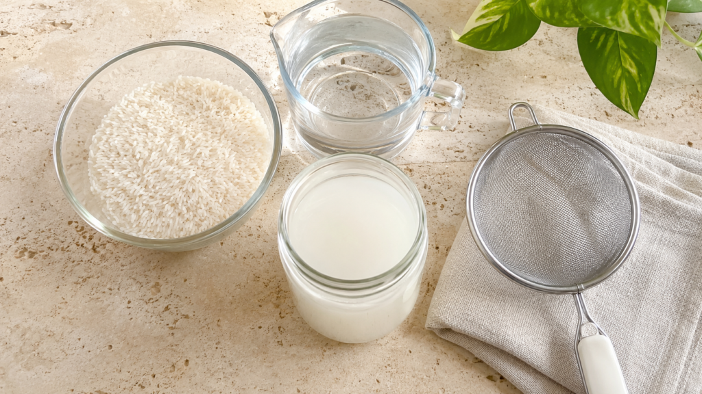 Ingredients and tools for making a homemade rice water hair rinse.