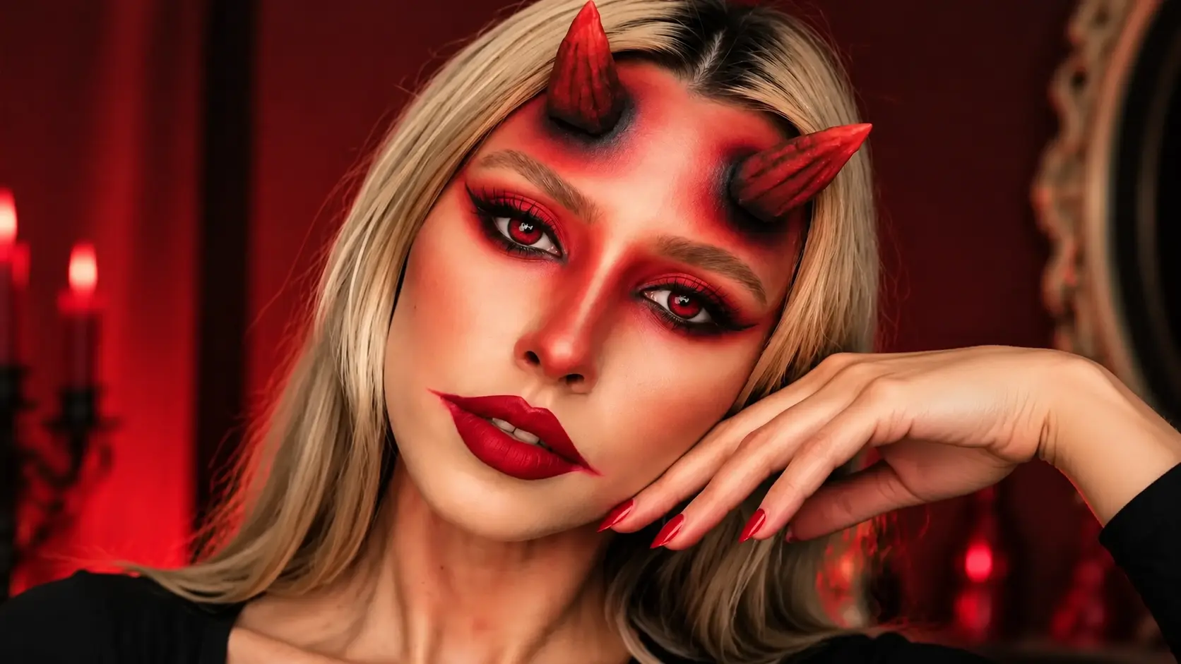 Glamorous devil makeup look featuring red horns, dramatic red and black eye makeup, bold lips, and a Halloween-inspired fantasy style