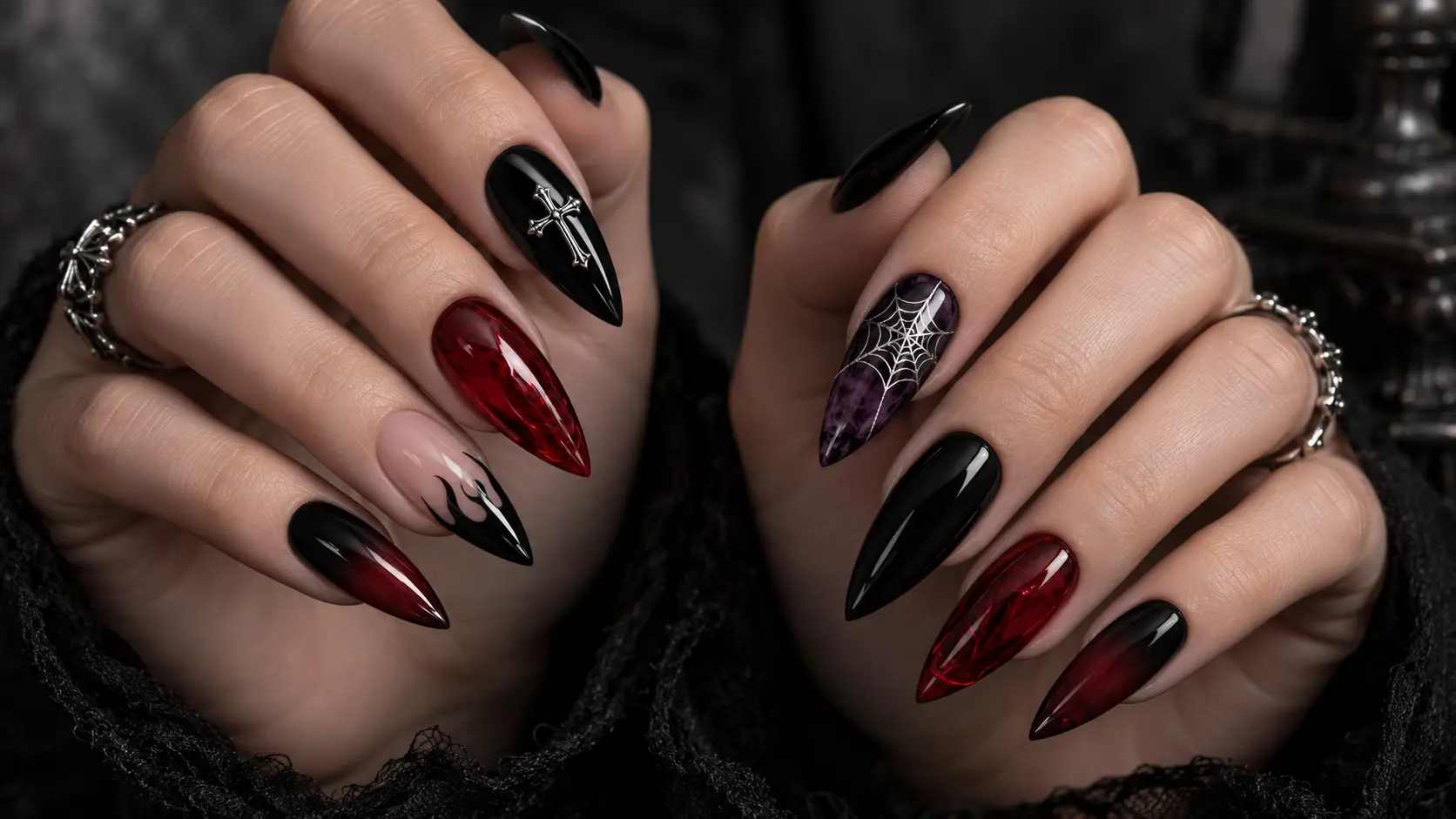 “Two hands showing goth nail designs with black flames, red glass nails, a silver cross, spiderweb art, and smoky black-to-red tips.”